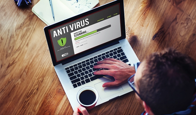Man on laptop, running antivirus software